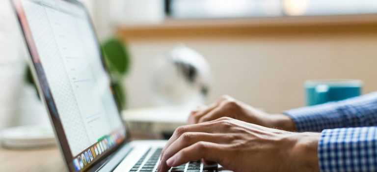 person typing on silver MacBook